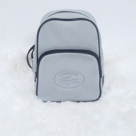 Lacoste mini backpack in a soft light blue shade with navy blue trim accents. - Picture 2 of 16